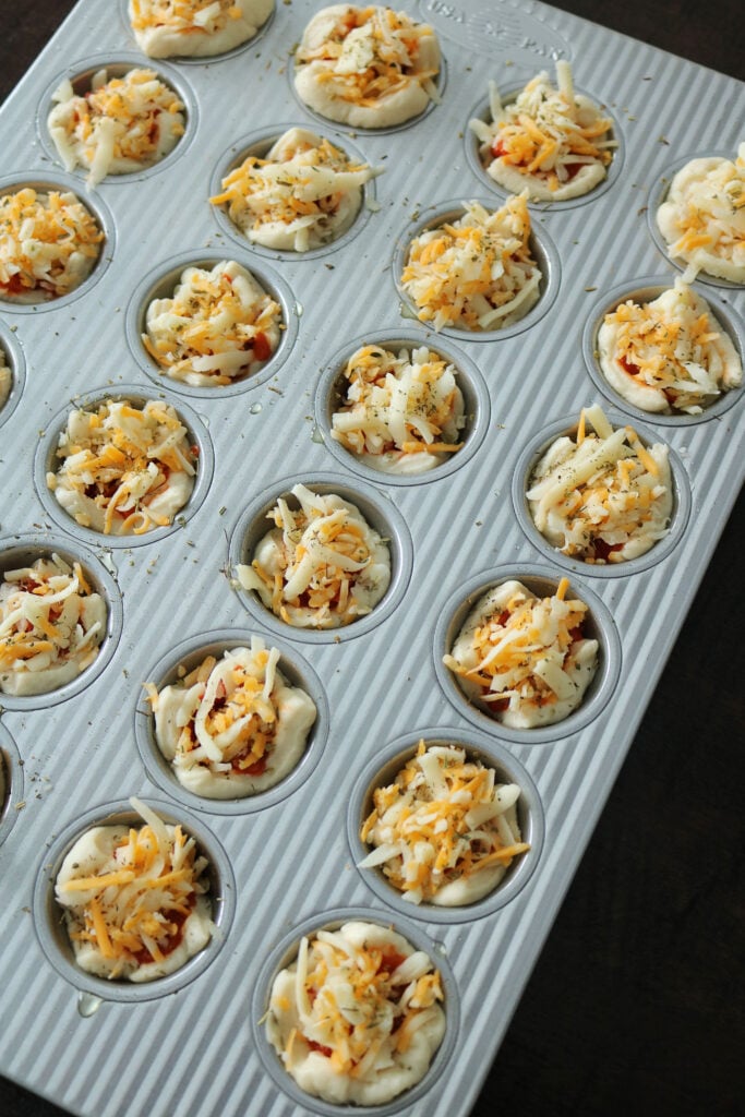 These Easy Mini Pepperoni Pizza Muffins are made with refrigerated pizza dough, pepperoni, cheese, pizza sauce, and Italian seasoning. Make these delicious pizza muffins for dinner in less than 20 minutes! #pizza #pizzarecipe #easydinner #appetizer