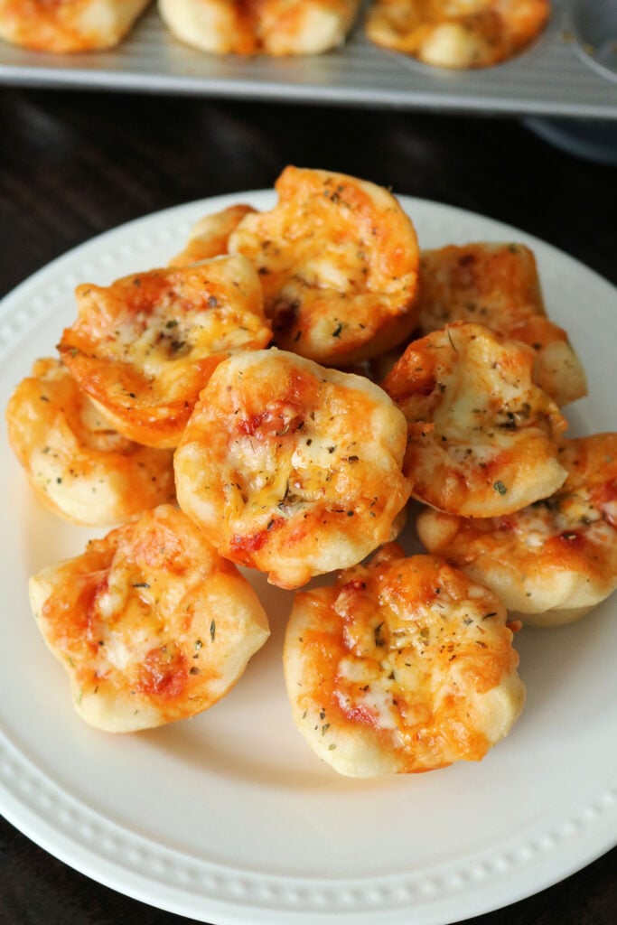 These Easy Mini Pepperoni Pizza Muffins are made with refrigerated pizza dough, pepperoni, cheese, pizza sauce, and Italian seasoning. Make these delicious pizza muffins for dinner in less than 20 minutes! #pizza #pizzarecipe #easydinner #appetizer